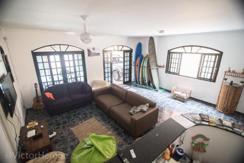 Vista aérea de una sala de estar con sofá y tablas de surf en Kionda Surf House en Bertioga