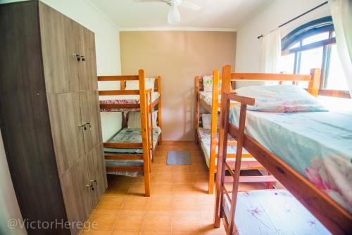 a bedroom with two bunk beds and a closet at Kionda Surf House in Bertioga