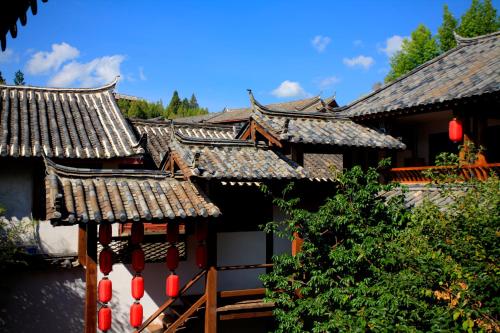 a group of buildings with roofs and red lanterns at Lijiang Merry Inn in Lijiang
