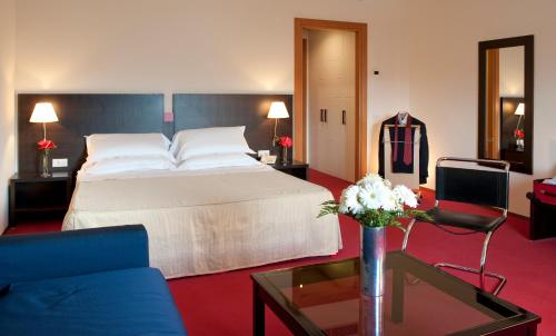 a hotel room with a bed and a couch and a table at Park Hotel Centro Congressi in Potenza