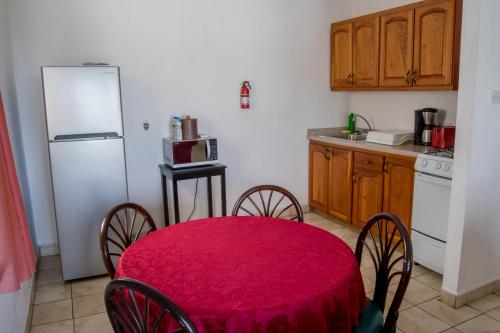 a kitchen with a table and chairs and a white refrigerator at Siesta Hotel in Morne Rouge