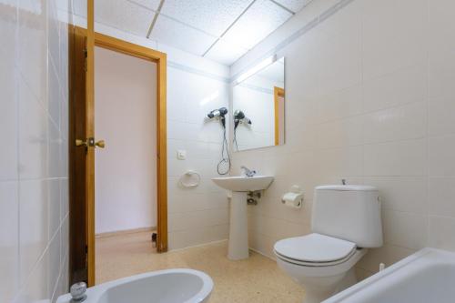 une salle de bains blanche avec toilettes et lavabo dans l'établissement Zeus Sant Jordi, à Salou