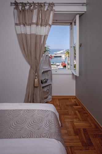 a bedroom with a window with a view of the ocean at Riva Apartments in Split