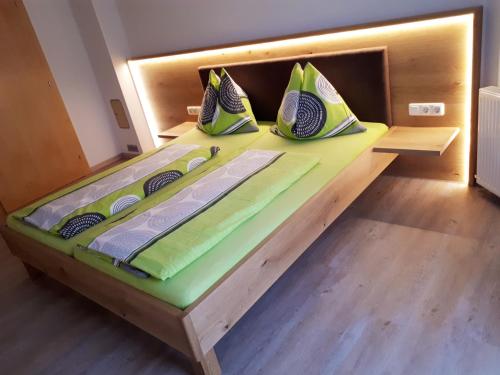 ein Holzbett mit Kissen darauf in einem Zimmer in der Unterkunft Ferienhaus Sporer in Iselsberg