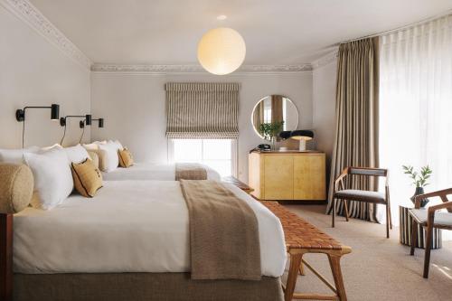 - une chambre avec un grand lit blanc et une chaise dans l'établissement Palihotel Westwood Village, à Los Angeles