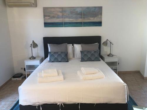 une chambre avec un grand lit blanc avec deux lampes dans l'établissement Luminous, street view studio, excellent location, à Beausoleil