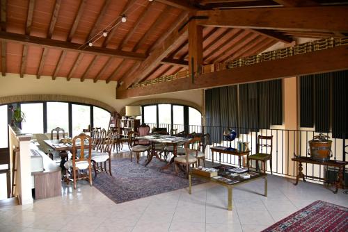 a dining room with tables and chairs and windows at Agriturismo Argaland in Parma