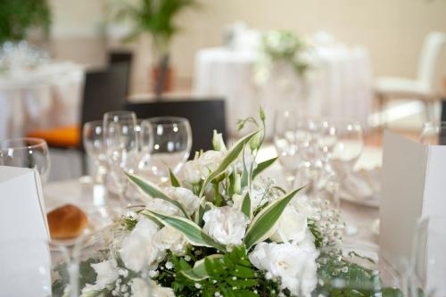 a table with white flowers and wine glasses at Park Hotel Centro Congressi in Potenza