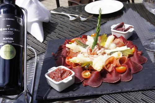 a plate of food on a table with a bottle of wine at The Christiania Mountain & Spa Resort in Zermatt