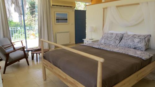a bedroom with a large bed with a wooden frame at ARTSEA Studio Apartment with sea view in ‘En Hod