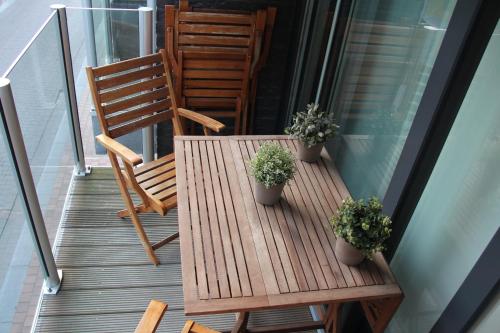 a porch with two chairs and a wooden table with plants at Littoral105 in Blankenberge