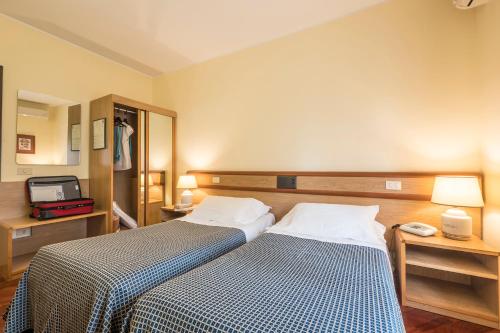 a hotel room with two beds and a television at Hotel Vega Perugia in Perugia