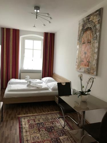 a bedroom with a bed and a table and a window at Hotel-Restaurant zum Donaueck Mauthausen in Mauthausen