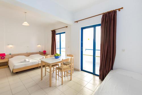 a bedroom with a bed and a table and a bed at Blue Roses in Ixia