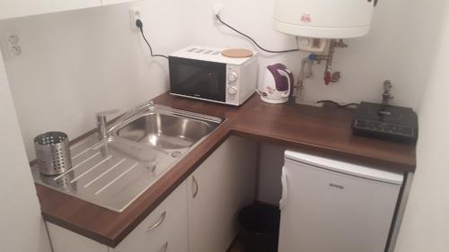 a small kitchen with a sink and a microwave at Apartmán - súkromie v meste (1) in Bratislava