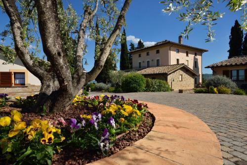 a flower bed in front of a house with a tree at Borgobrufa Spa Resort Adults Only in Brufa