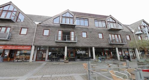 a large wooden building with windows and tables and chairs at Yachtsmans Rest in Falmouth