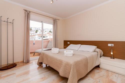 um quarto com uma cama com duas toalhas em Burriana Playa Ibnsadi Nerja em Nerja