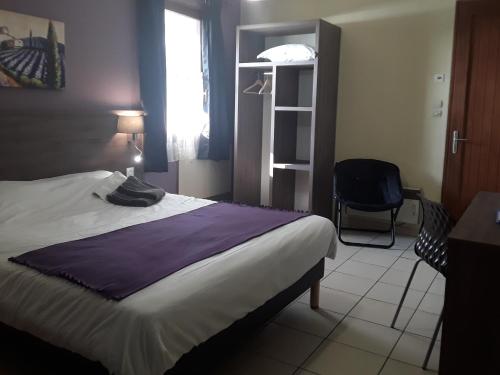 a bedroom with a bed and a desk and a chair at Relais Motel de Maisonnay in Maisonnay