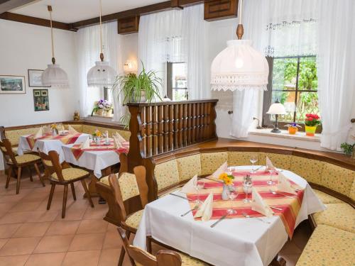 Landhotel Zum Hammer في Tannenberg: غرفة طعام مع طاولتين وكراسي