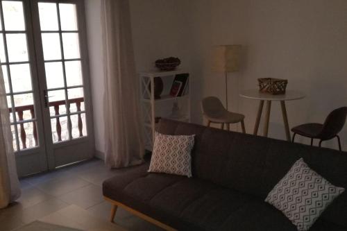 un salon avec un canapé et une table avec des chaises dans l'établissement appartement au coeur de la cité, à Sarlat-la-Canéda