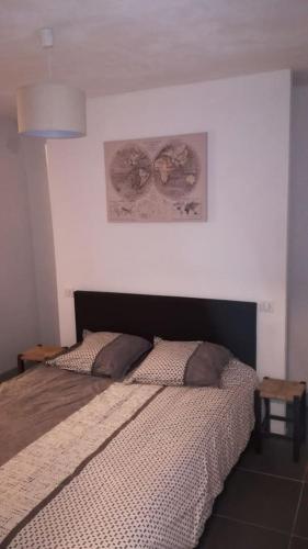 une chambre avec un lit et un tableau au mur dans l'établissement appartement au coeur de la cité, à Sarlat-la-Canéda