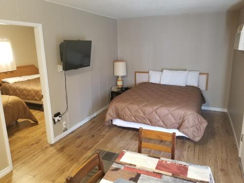 a bedroom with a bed and a television in it at Apple Tree Inn in Penticton