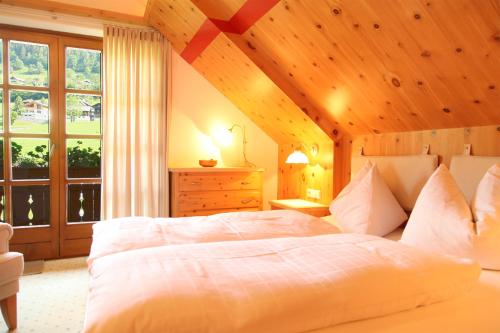 a bedroom with a large bed with a wooden ceiling at Unterwirt in Bad Kleinkirchheim