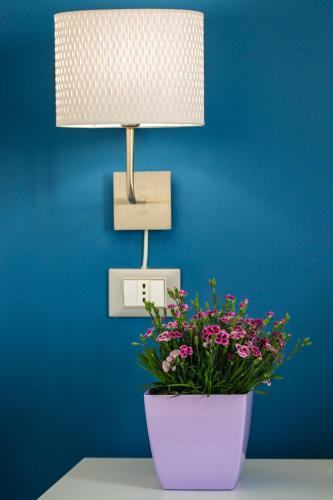 a lamp and a flower pot on a table with a plant at Le Due Sicilie B&B in Lascari
