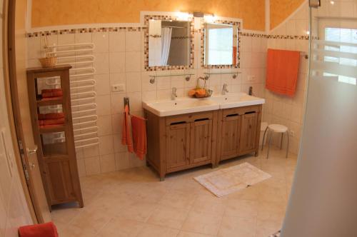 ein Bad mit einem Waschbecken und einem Spiegel in der Unterkunft Traum-Ferienwohnungen Wechselberger Schwendau in Schwendau