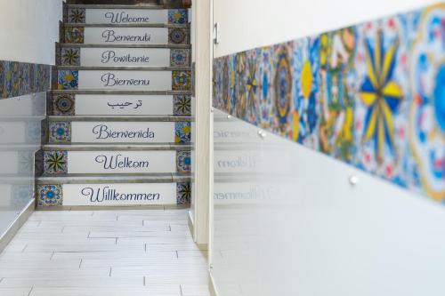 a hallway with a stairwell with paintings on the wall at Le Due Sicilie B&B in Lascari
