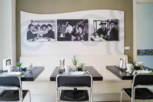 a dining room with tables and chairs and pictures on the wall at Le Due Sicilie B&B in Lascari