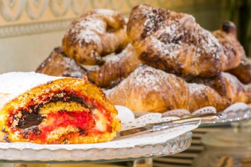 a pile of pastries on a plate on a table at Hotel Vega Perugia in Perugia