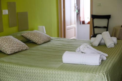 a green bed with towels and pillows on it at St. Michele b&b in Patti