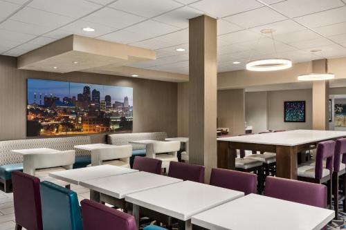 a dining room with tables and chairs and a tv at Baymont by Wyndham Springfield I-44 in Springfield