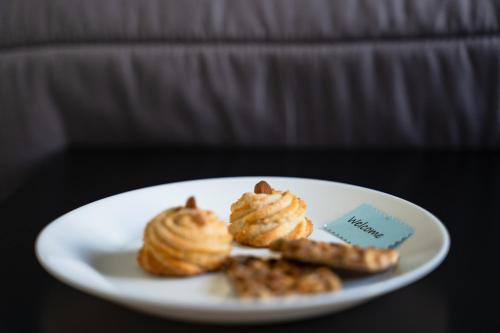 a white plate with pastries and cookies on a table at Le Due Sicilie B&B in Lascari
