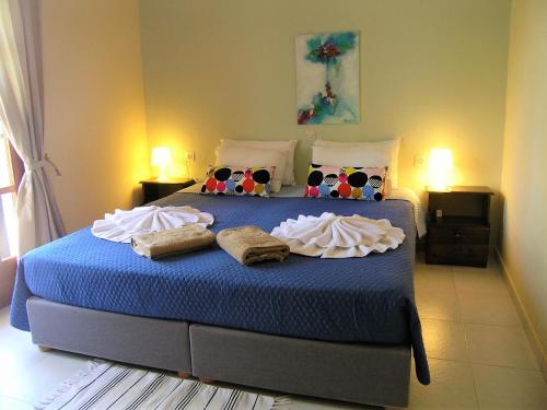 a bedroom with a bed with blue sheets and pillows at Emerald in Plaka