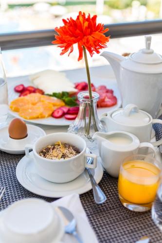 a table with a bowl of food and a flower in a vase at The Navigator - Solaqua in Albufeira