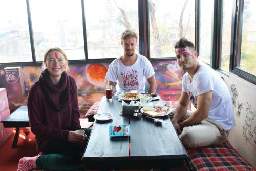 a group of three people sitting at a table at Rest Up Kathmandu Hostel in Kathmandu