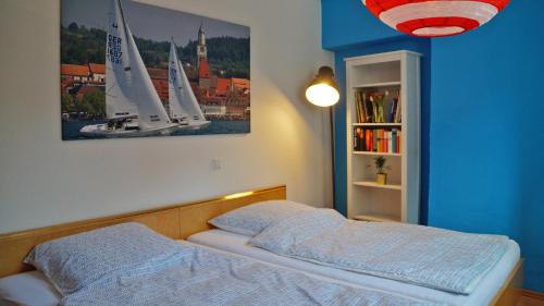 a bedroom with a bed and a picture of sailboats at Ferienwohnung am Münsterturm in Überlingen