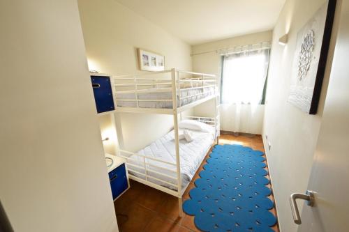 ランポーヤにあるLavandaの二段ベッドと青いラグが備わる小さな客室です。