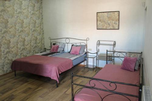 sypialnia z 2 łóżkami i krzesłem w obiekcie 3 Studio w mieście Tbilisi City