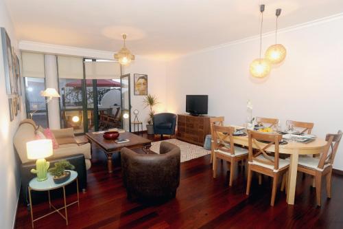 a living room with a table and a dining room at Apartamento Quinta do Faial in Funchal