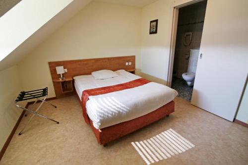 a bedroom with a large bed in a room at Hôtel Restaurant Au Coucou in Pulversheim