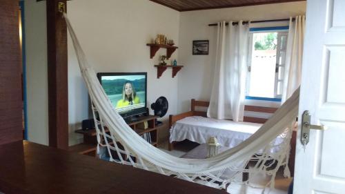 a bedroom with a hammock in a room at Casa no Centro de Búzios in Búzios