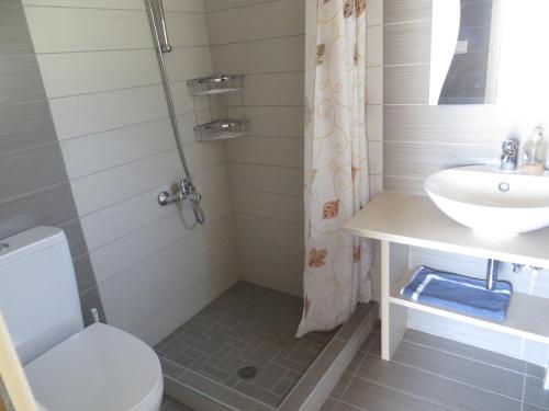 a bathroom with a sink and a toilet and a shower at Nicolas Apartments in Ierapetra