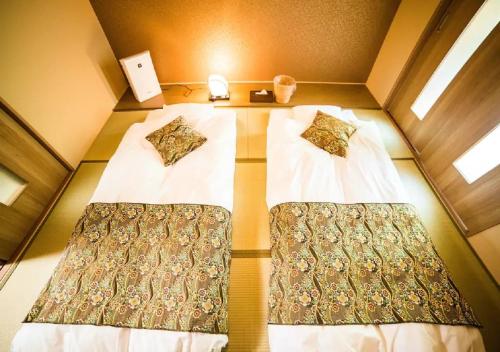 Kyoto - House / Vacation STAY 3816 في كيوتو: سريرين في غرفة صغيرة بها