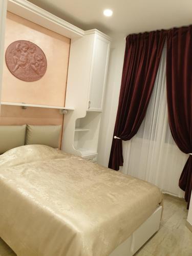 1 dormitorio con cama y cortina roja en Museum Guest House, en Civitavecchia