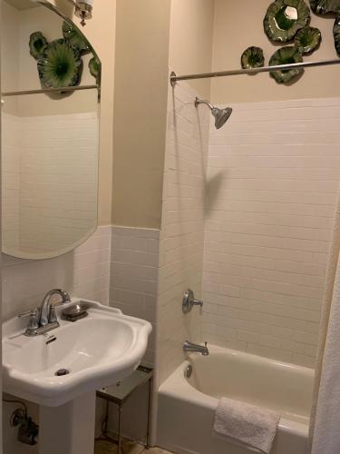 a white bathroom with a sink and a bath tub at Terrell House Bed and Breakfast in New Orleans