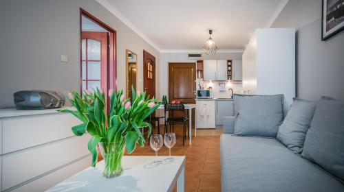 a living room with a couch and a table with wine glasses at Apartament w Centrum in Ustka